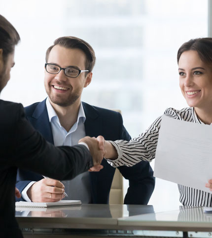 Two professionals shaking hands in agreement during a business meeting.