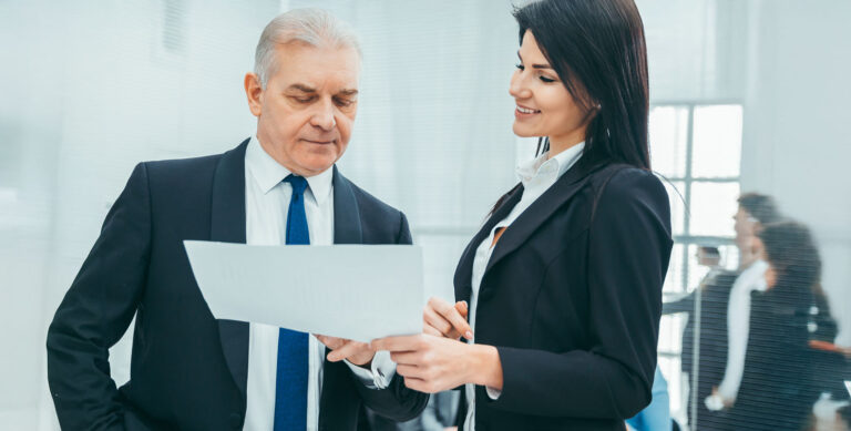 A paralegal in a business suit discusses documents with a senior lawyer, challenging common myths about the paralegal profession.